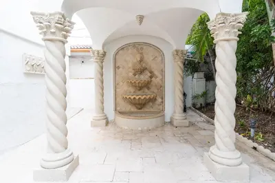 a fountain in the courtyard of a house with columns at Oceana Blue / Beach Front / Pool / Bar / Relax in Fort Lauderdale