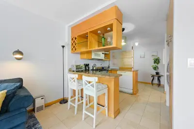 a kitchen with a sink and a counter with stools at Cozy studio, walk to the beach, restaurants, bars in Miami Beach