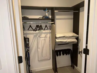 a walk in closet with black shelves and shoes at Exceptional Studio with King Bed and Queen Sofa-bed in Miami