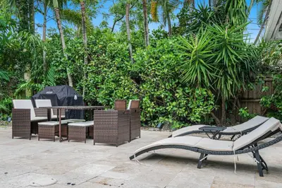 a patio with chairs and a table and a table and chairs at Modern 4BR Villa with Pool - Outdoor amenities - WFH in Fort Lauderdale