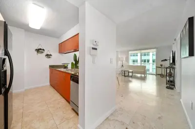 a kitchen with white walls and an open floor plan at Penthouse APT w Private Balcony King Bed Parking in Miami