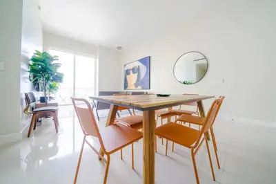 a dining room with a wooden table and chairs at Ocean view Work from Home Balcony Parking Pool in Miami