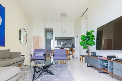 a living room with purple chairs and a glass table at Ocean view Work from Home Balcony Parking Pool in Miami