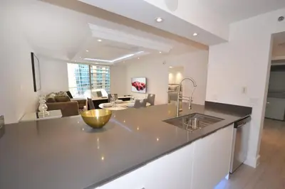 a kitchen with a counter top and a living room at LUXURY CONDO LOCATED iN THE HEART OF MIAMI in Miami