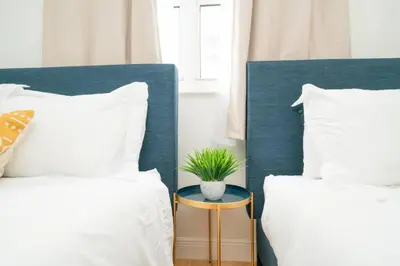 two beds with white pillows and a plant on a table at 2Bed 2 Bath Airbnb Friendly building with Pool, Hot Tub, and Gym in Miami