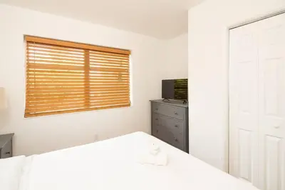 a white bedroom with a bed and a window at Modern 5 Bedroom Miami Home 15 Min to the Beach in Miami