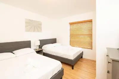 a bedroom with two beds and a window at Modern 5 Bedroom Miami Home 15 Min to the Beach in Miami