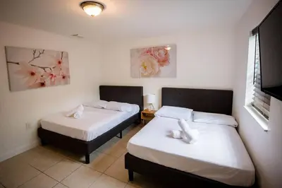 a bedroom with two beds with white sheets at 3 Bedroom Miami Home 15 Minutes to the Beach in Miami