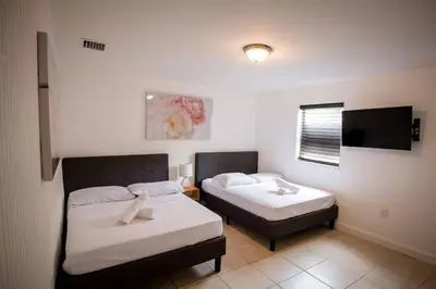 a room with two beds and a flat screen tv at 3 Bedroom Miami Home 15 Minutes to the Beach in Miami