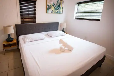 a bed with two white towels on top of it at 3 Bedroom Miami Home 15 Minutes to the Beach in Miami