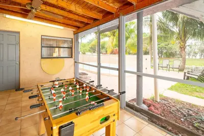 a room with a foosball table in front of a window at Waterfront 2-Story Villa with Heated Pool in Pembroke Pines