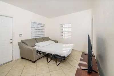 a living room with a couch and a flat screen tv at Beautiful 7-Bedroom Villa with Pool in Hialeah