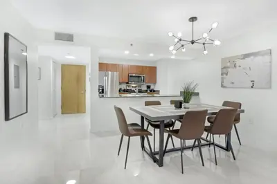 a kitchen and dining room with a table and chairs at Deluxe 1 BR suite with Pool, Parking, Balcony and Ocean Views in Miami