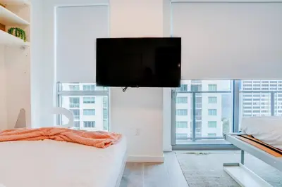 a bedroom with a flat screen tv above a bed at Modern and newly built studio with Pool, Gym, and Restaurant access in Miami