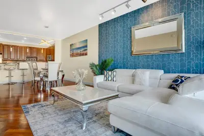 a living room with a couch and a table at Lux 2BR Condo in Ocean Reserve with Pools and Tennis Courts in Miami Beach