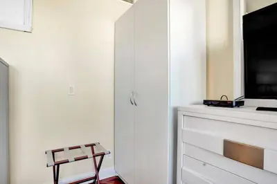 a white living room with a tv and a fireplace at Lux 2BR Condo in Ocean Reserve with Pools and Tennis Courts in Miami Beach