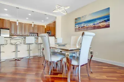 a dining room with a table and white chairs at Lux 2BR Condo in Ocean Reserve with Pools and Tennis Courts in Miami Beach