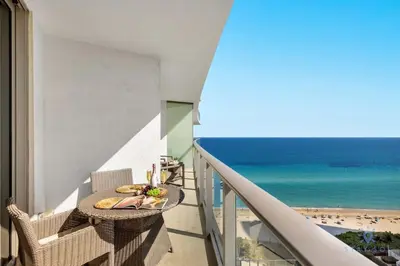 a balcony with a table and a view of the beach at Ocean View Balcony, Beachfront Resort, Pools, Gym in Hollywood