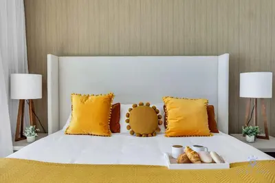 a bedroom with a white bed with yellow pillows at Ocean View Balcony, Beachfront Resort, Pools, Gym in Hollywood