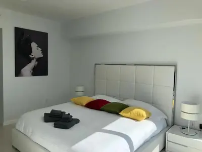 a bedroom with a large white bed with colorful pillows at Amazing unit Miami Brickell with Sea & City View in Miami
