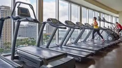 a woman running on a treadmill in a gym at Amazing unit Miami Brickell with Sea & City View in Miami
