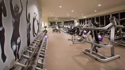 a gym with rows of tread machines on a wall at Amazing unit Miami Brickell with Sea & City View in Miami