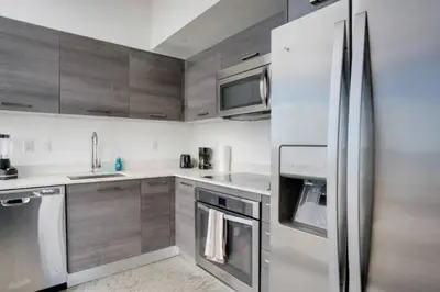 a kitchen with a stainless steel refrigerator and cabinets at Sun-Splashed 1BR Condo unit in DWTN Miami with WFH in Miami