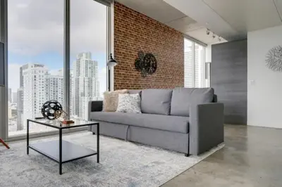 a living room with a couch and a brick wall at Sun-Splashed 1BR Condo unit in DWTN Miami with WFH in Miami