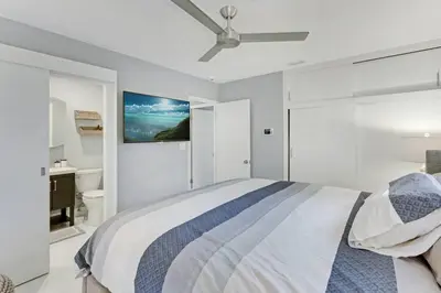 a white bedroom with a bed and a ceiling fan at Modern 2BRHouse in Wilton Manors with a Heated Pool and KING Bed in Fort Lauderdale