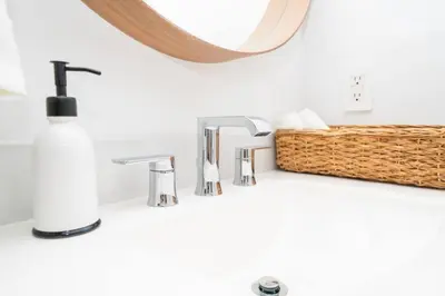a bathroom sink with a soap dispenser and a mirror at LuxBright 1BR Brickell Paradise with Oceanview and Parking in Miami