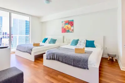 two beds in a room with a large window at Ocean and City Views Lux Miami Brickell Sleeps 5 in Miami