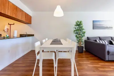 a white dining room table with white chairs and a couch at Ocean and City Views Lux Miami Brickell Sleeps 5 in Miami