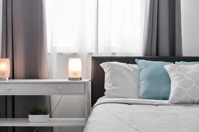 a bedroom with a bed with a nightstand and two lamps at Waterfront Luxury 2-Bedroom Condo Sunny Isles Beach in Miami Beach