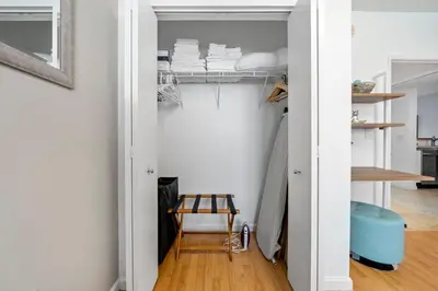 a room with white walls and a closet with a wooden stool at Waterfront Luxury 2-Bedroom Condo Sunny Isles Beach in Miami Beach