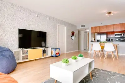 a living room with a tv and a white table at Ocean and City Views Lux Miami Brickell Condo Sleeps 4, King Bed in Miami