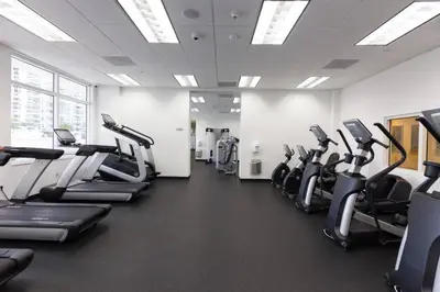a gym with treadmills and elliptical machines at Sunshine Ocean and City Views 1 BR Paradise with Parking in Miami