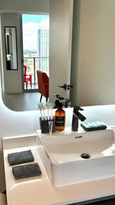 a bathroom with a white sink and a mirror at Sky-High oasis heated Pool & Gym Miami Skyline Vista in Miami