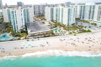an aerial view of a beach in front of a city at Beachfront 1-Bedroom Apartment with Ocean View, Pool and Gym in Hollywood Beach in Hollywood