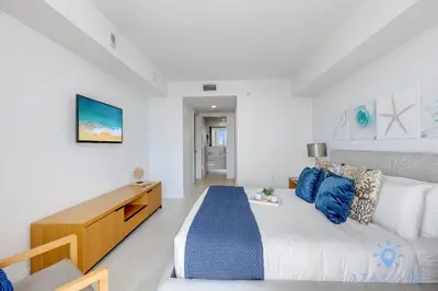 a white bedroom with a bed and a desk at Infinite View Balcony with Pool, Gym and Near Beach in Hallandale Beach
