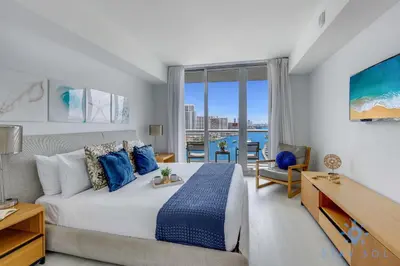 a bedroom with a bed and a view of the ocean at Infinite View Balcony with Gym, Pool and Near Beach in Hallandale Beach