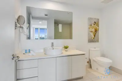 a white bathroom with a sink and a toilet at Infinite View Balcony with Gym, Pool and Near Beach in Hallandale Beach