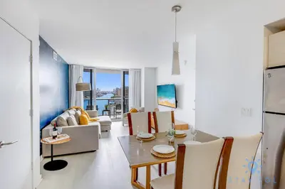 a living room with a table and chairs at Infinite View Balcony with Gym, Pool and Near Beach in Hallandale Beach