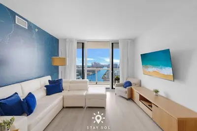 a living room with a white couch and blue walls at Balcony with View, Pool, Gym, Near Beach in Hallandale Beach