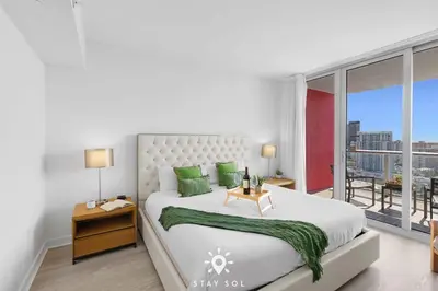 a bedroom with a large bed and a large window at Balcony with View, Pool, Gym, Near Beach in Hallandale Beach