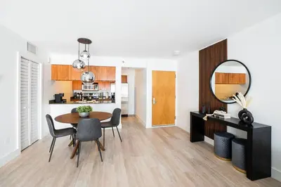 a dining room with a table and chairs and a mirror at City views at brickell miami in Miami
