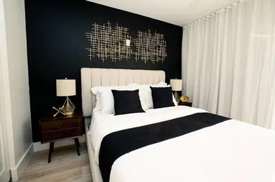 a bedroom with a white bed and a black wall at City views at brickell miami in Miami