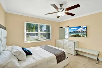 a bedroom with a bed and a ceiling fan at Deluxe Home Heated Pool & Jetted Tub near Beach in Dania Beach