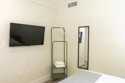 a bedroom with a flat screen tv on the wall at Oia House Brickell Beach 10 minutes Pool Location in Miami