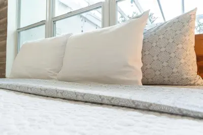 a bed with white pillows and a window at Oia House Brickell Beach 10 minutes Pool Location in Miami