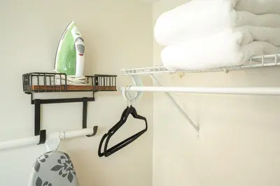 a bathroom with white towels and a shelf with towels at Oia House Brickell Beach 10 minutes Pool Location in Miami